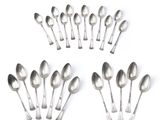 six silver spoons are arranged in a circle on a white surface