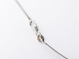 a close up of a silver chain on a white surface