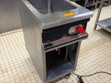 un évier au milieu d'une cuisine, avec en arrière-plan de nombreux appareils électroménagers en inox