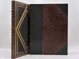 a black and brown book with gold trims on a white background