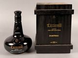 la bouteille se trouve à côté d'une boîte en bois avec un couvercle noir