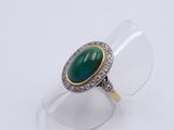 a close up of a ring with a green stone on it