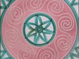 a pink and blue tile with a circular design on it