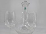 two wine glasses and a decanter sitting on a table