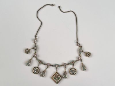 une photo d'un collier en argent orné de diverses breloques