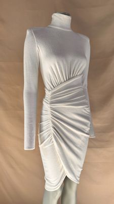 the mannequin is wearing a white dress with long sleeves