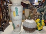 un vase blanc posé sur une table sur laquelle se trouvent d'autres objets