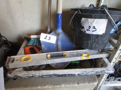 certains outils sont posés sur une étagère, à côté d'un seau et d'une règle