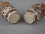 pair of asian vases on a gray surface with a gray background