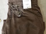 a pair of brown pants on the floor next to a pair of scissors