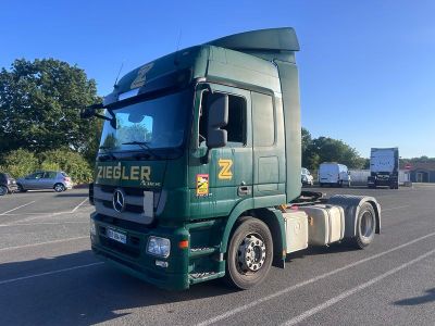 un camion vert garé sur un parking