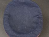 navy blue hat with red trim on a black surface