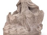 statue of a woman sitting on a rock on a white background
