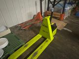 un chariot élévateur jaune garé dans un entrepôt à côté d'autres palettes