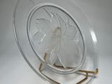 a glass plate with a flower on it on a stand