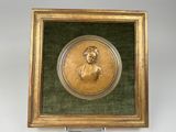 une image représentant un tableau d'une femme, dans un cadre doré