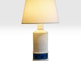 un gros plan d'une lampe posée sur une table, avec un abat-jour blanc