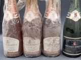 three bottles of champagne and a bottle of wine wrapped in plastic