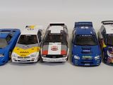 several toy cars are lined up in a row on a white surface