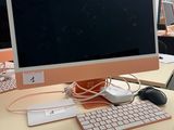 a computer monitor sitting on a desk with a keyboard and mouse