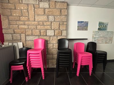 de nombreuses chaises dans une pièce avec un mur de briques en arrière-plan
