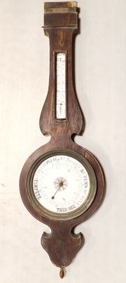 une horloge en bois accrochée au mur, sur laquelle se trouve un baromètre