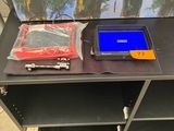 une photo montrant un tableau et un ordinateur portable posés sur une table