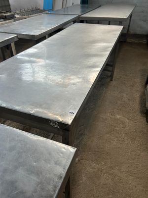 plusieurs tables et bancs dans une pièce dont la porte est bleue