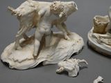 two figurines of a man and a woman on a rock