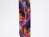 a skateboard with a colorful design on it sitting on a white surface