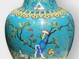 a blue vase with a picture of a woman in a garden on it