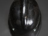 a close up of a black helmet on a gray surface
