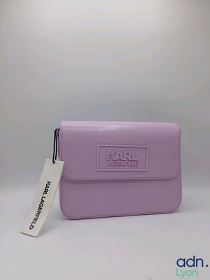 un sac à main violet muni d'une étiquette, posé sur une table