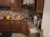 a small kitchen with wooden cabinets and tile flooring