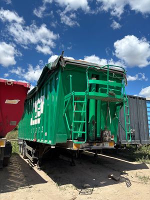 un wagon vert garé à côté d'un wagon rouge