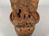 carvings of animals in a vase on a white background