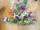 a bag full of plastic toys on a wooden table