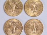 four gold coins with angels on them sitting on a white surface
