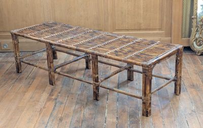 a bench made out of bamboo sticks on a wooden floor