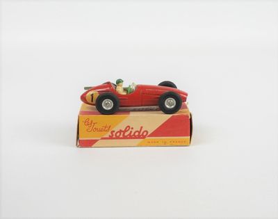 une petite voiture rouge posée sur une boîte