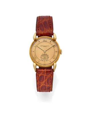 une montre-bracelet en or avec un bracelet en cuir marron
