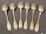 six silver spoons are lined up in a row on a table