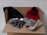une boîte en carton remplie de vêtements posée sur une table blanche