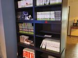 une bibliothèque noire remplie de livres dans un salon