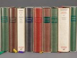 several books are lined up in a row on a gray surface