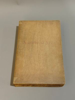 an old book sitting on top of a table next to a cup of coffee