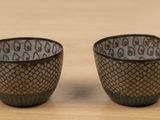 pair of black and white ceramic cups on a wooden table