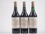trois bouteilles de vin posées les unes à côté des autres sur une surface blanche