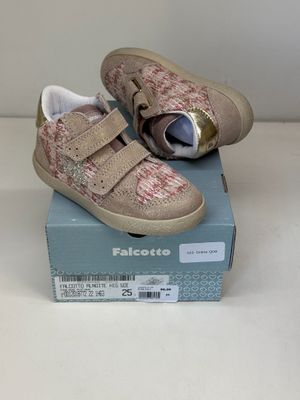 une paire de chaussures pour tout-petits dans une boîte posée sur une surface blanche