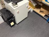 un ordinateur et une imprimante posés sur un bureau dans un coin de la pièce